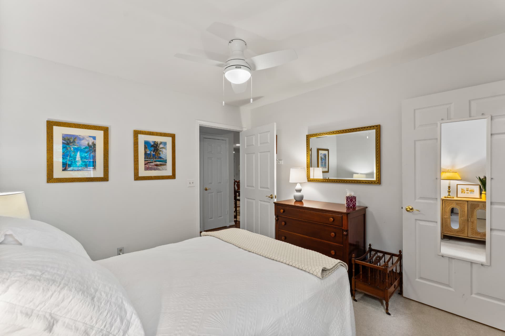 508 Limerick Circle Unit 303 — guest bedroom with framed coastal art, dresser and ceiling fan