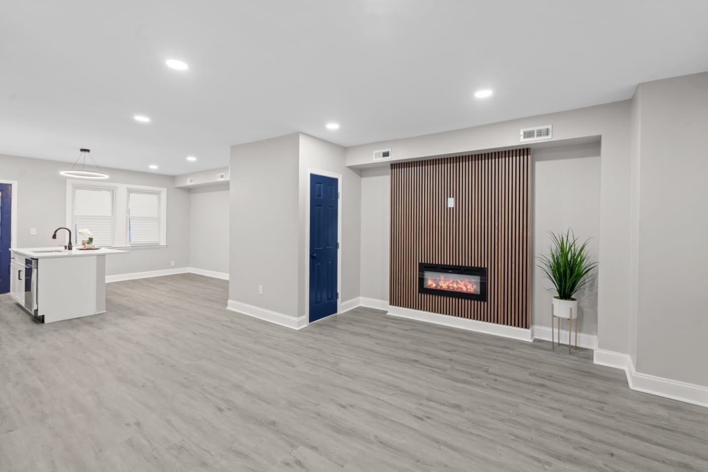 Living area with slatted wood accent wall and linear fireplace