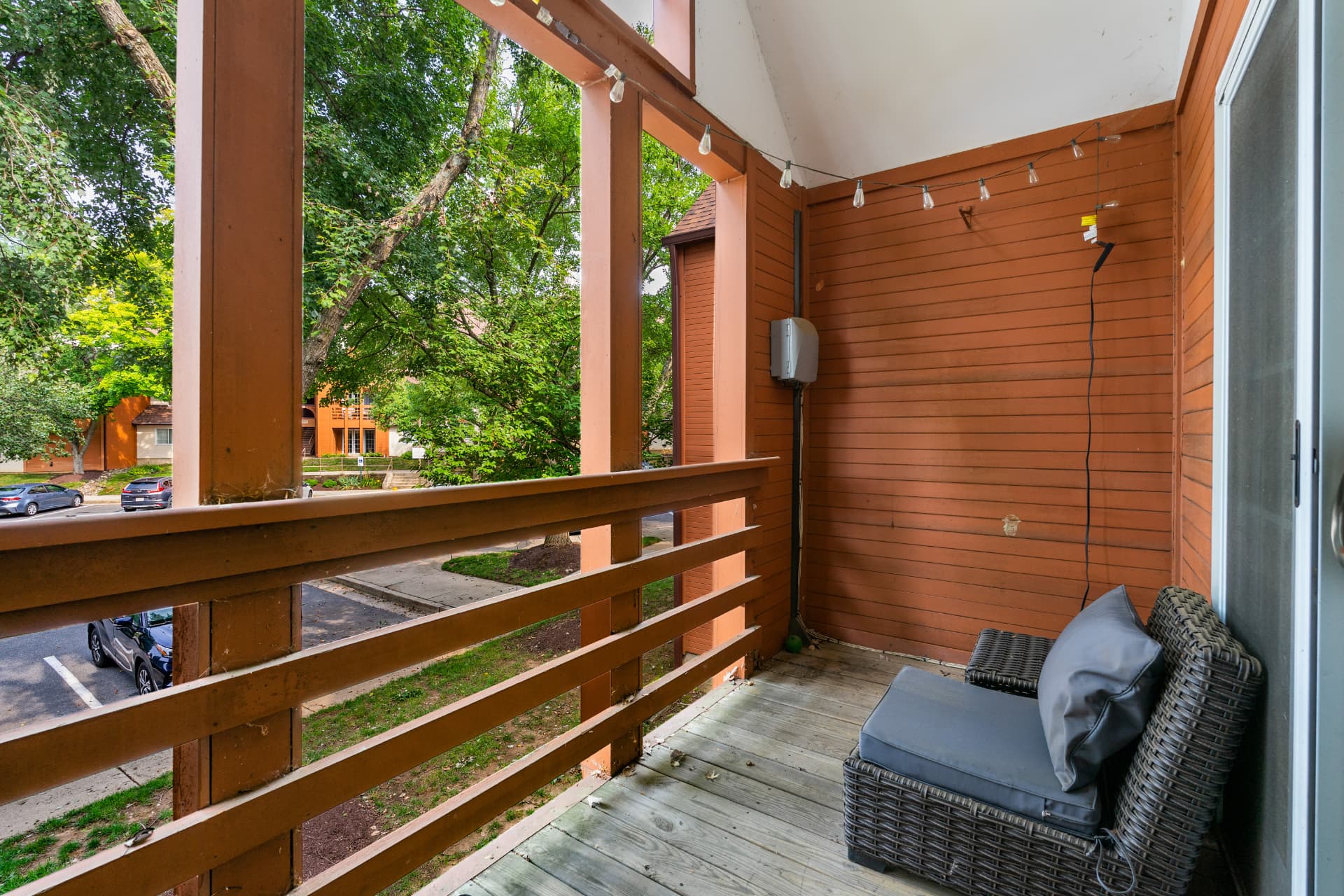 4924 Columbia Road Unit 5 — private balcony with wicker seating and string lights